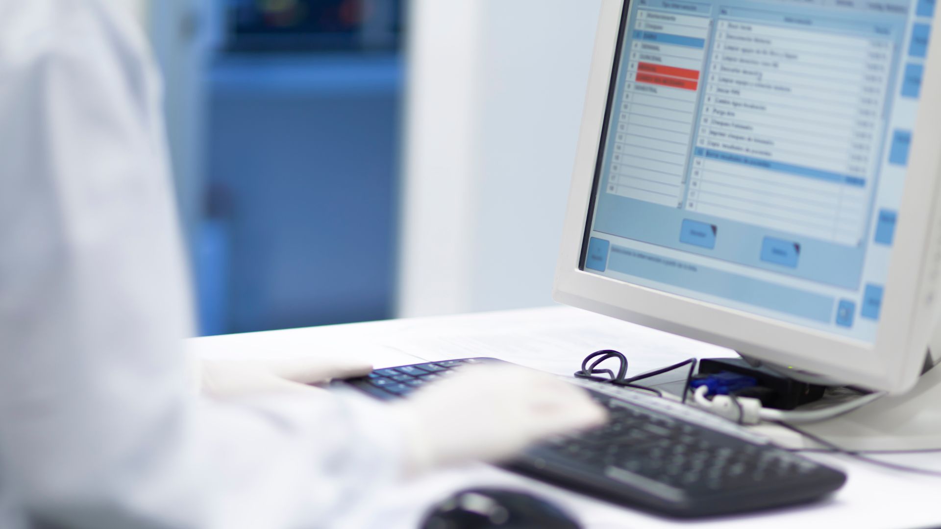 A person in a lab coat and gloves types on a keyboard, their actions illuminated by the glow of a computer screen displaying data. As they work, Delta4 secures European patents in the background, symbolizing innovation and meticulous research at its finest.