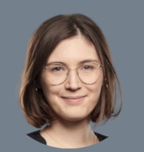A member of Delta4's team with short brown hair, wearing round eyeglasses and smiling slightly, is pictured against a plain grey background.