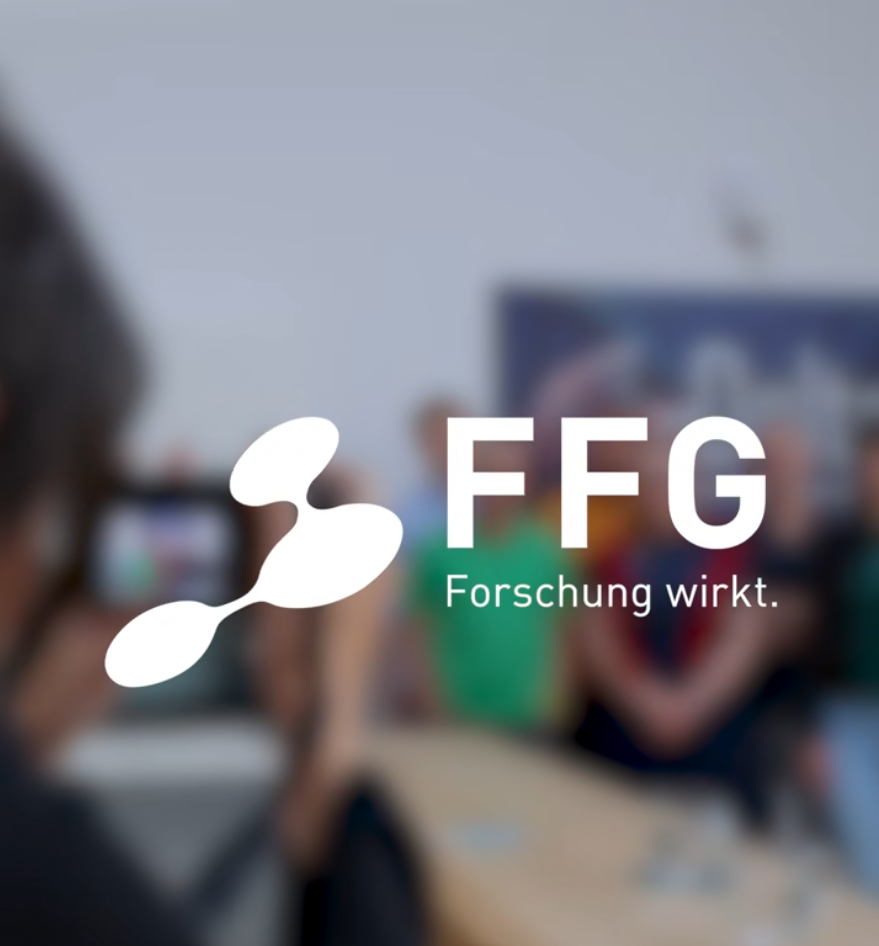 A blurred group photo is being taken indoors, with the FFG logo and the words "Forschung wirkt." prominently displayed in the foreground, celebrating the success stories behind innovative research.